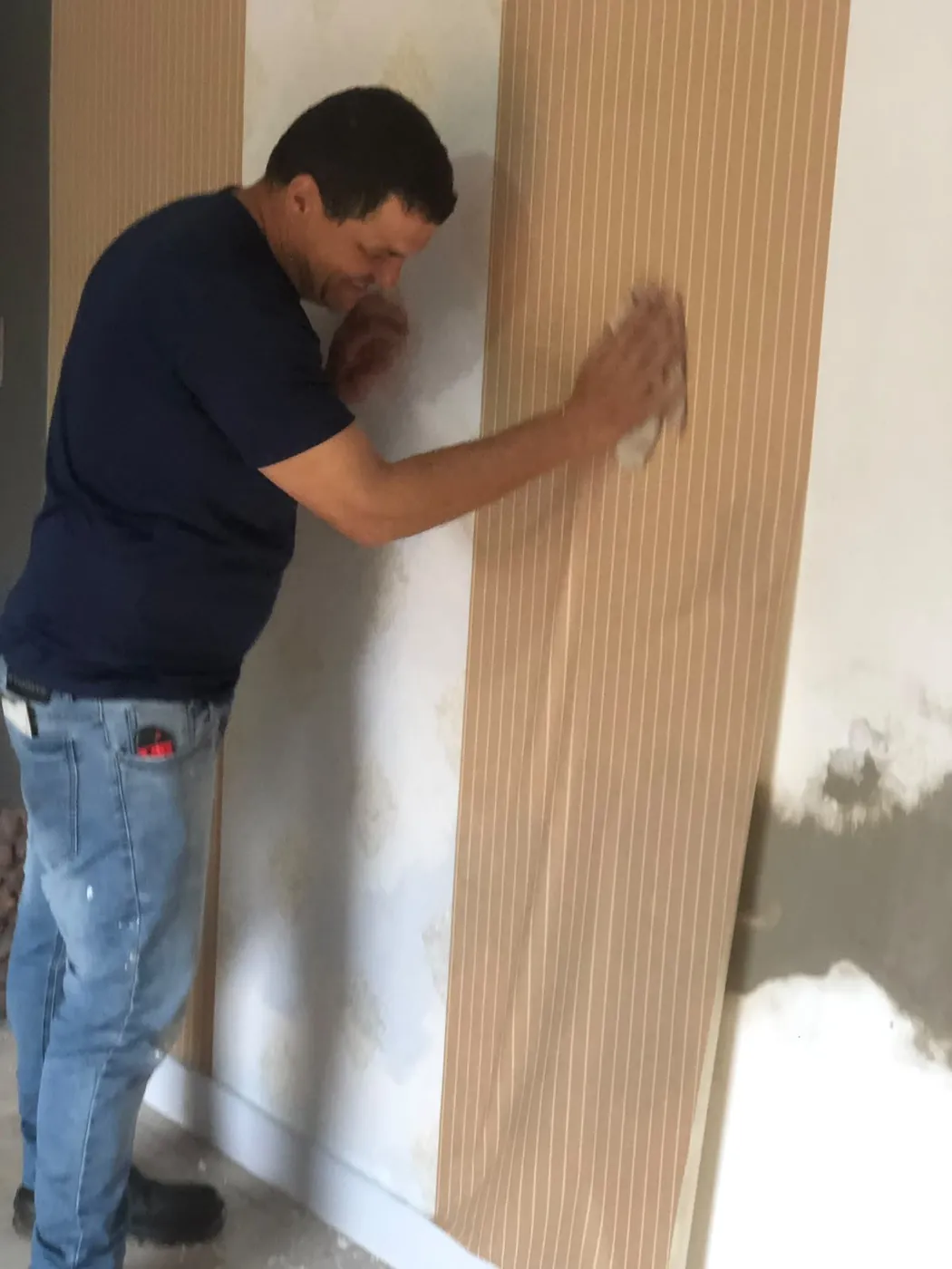 Profissional da Silva instalando painel ripado em parede recuperada