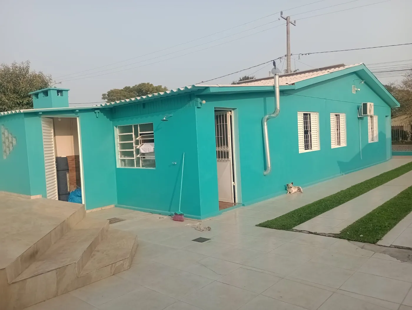 Residência pintada por fora, com muro e calçada
